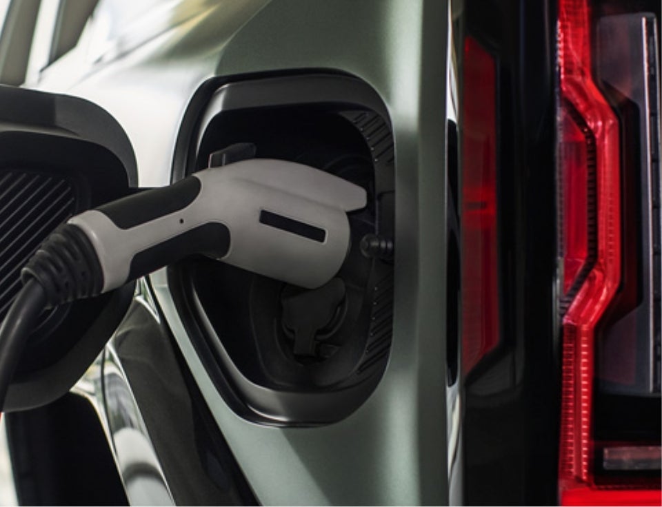 Close up of charging port with charger plugged in on a GMC Hummer EV SUV - North Country GMC in HIBBING MN