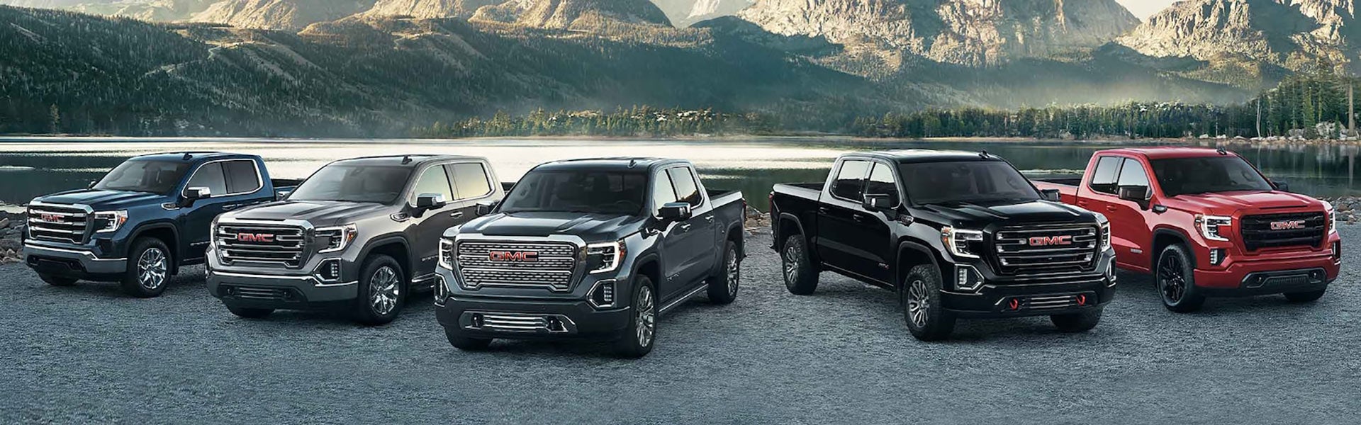 Multiple GMC Sierra 1500 Lineup near River with hills and jungle