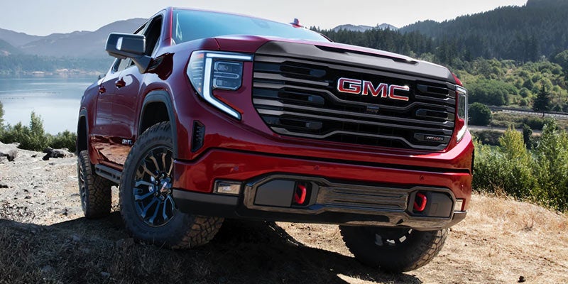 Red GMC Sierra AT4X off-road truck on rocky terrain